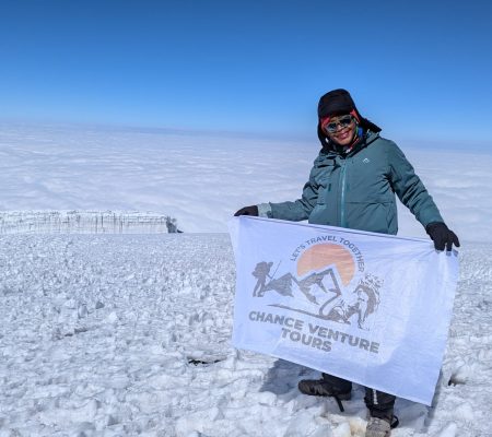 "Our happy client proudly flew our company flag at Uhuru Peak, the highest point of Mount Kilimanjaro. Standing beside the majestic glaciers, they celebrated their successful summit with a joyful moment that reflects the spirit of adventure and achievement we strive to offer every climber.